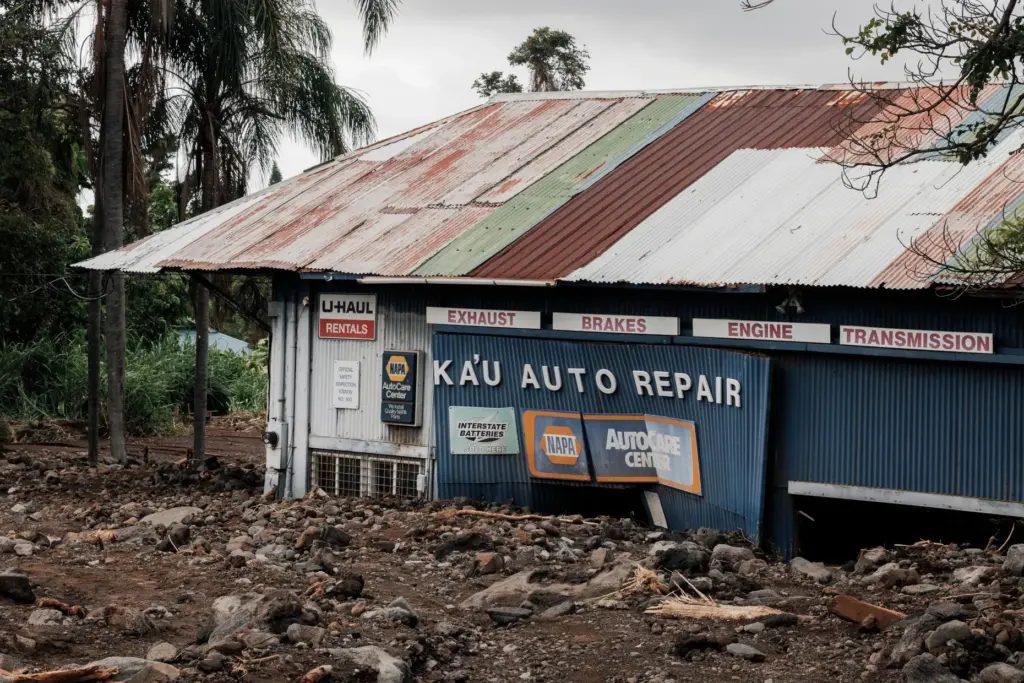 Ka’u Auto Repair Shop is seen surrounded by a field...