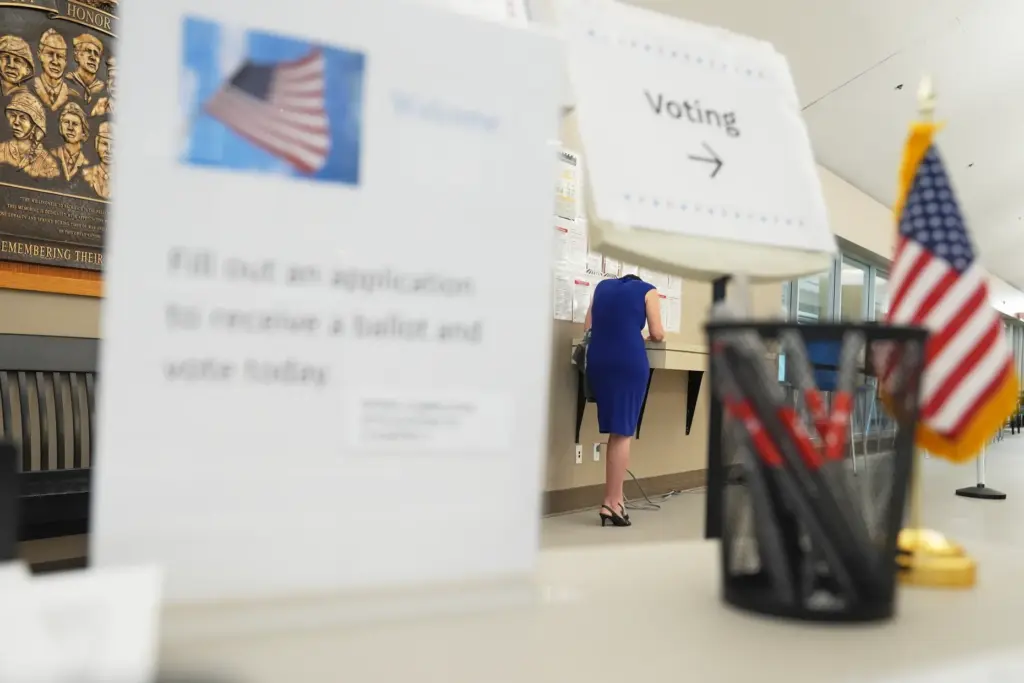 A voter fills out paperwork before casting a ballot on...