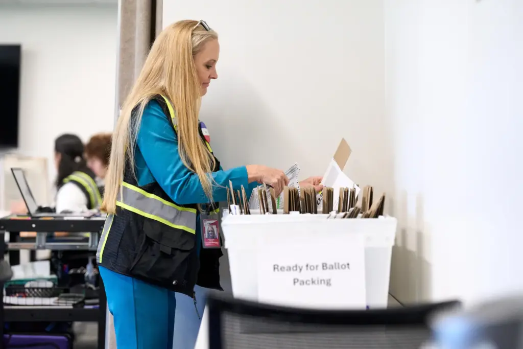 Wake County Board of Elections employees prepare absentee ballots to...
