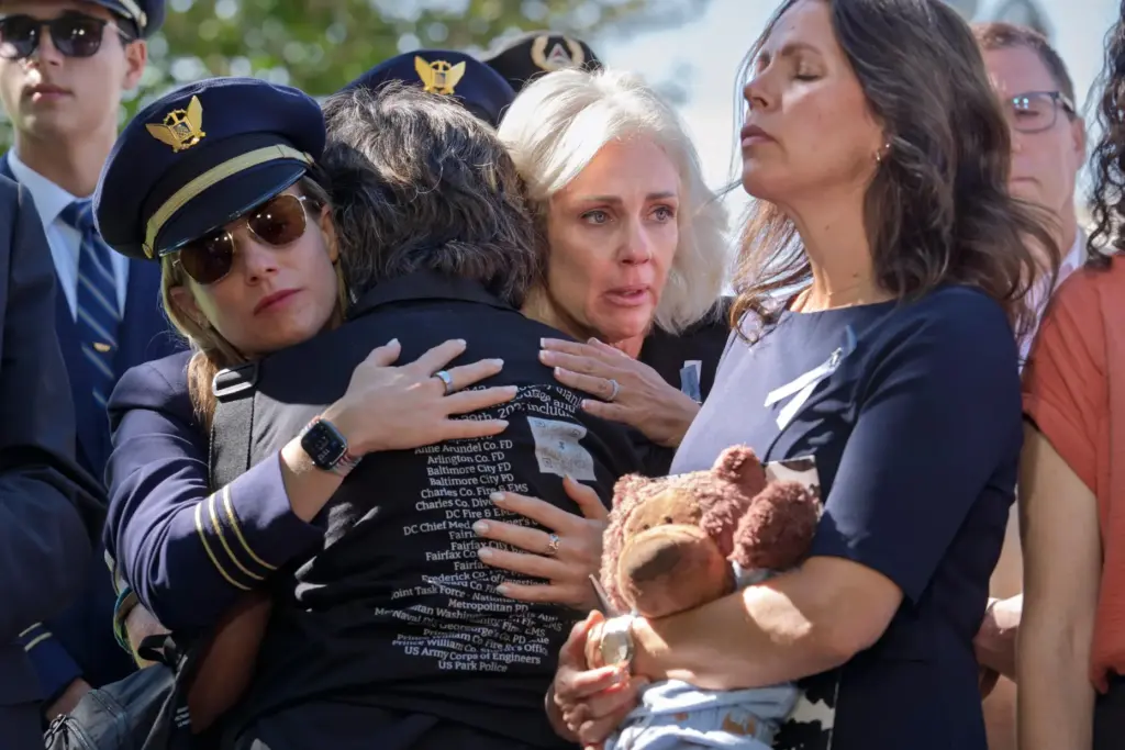 National Transportation Safety Board Chair Jennifer Homendy, center, helps to...