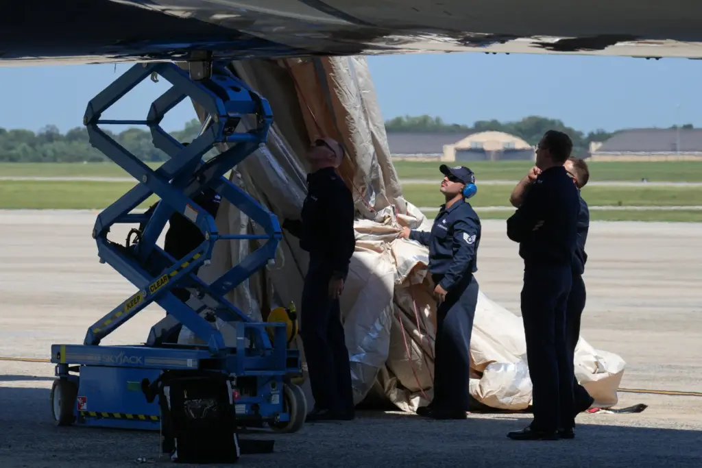 U.S> Air Force personnel work after an emergency inflatable slide...
