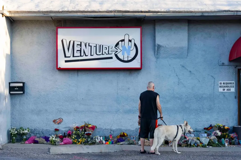 A passerby looks at a growing memorial outside the Venture-N...