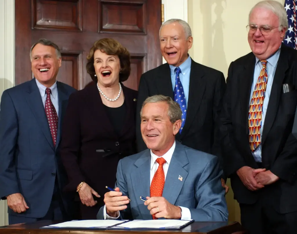 FILE – President George W. Bush shares a laugh with,...