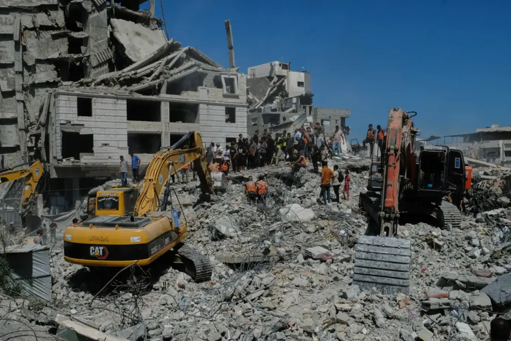 Palestinian civil defense crews search for bodies and survivors in the rubble of a collapsed building.