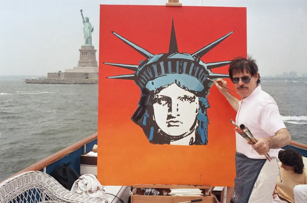 FILE – Artist Peter Max works on a painting of...