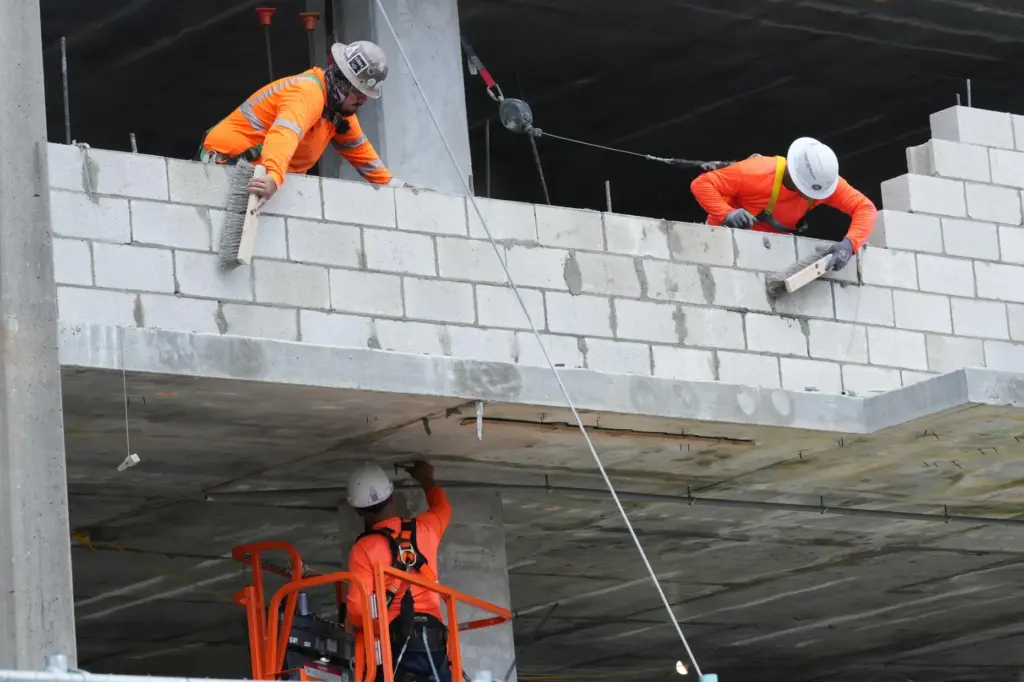 Construction workers assemble a floor on a luxury residential building...