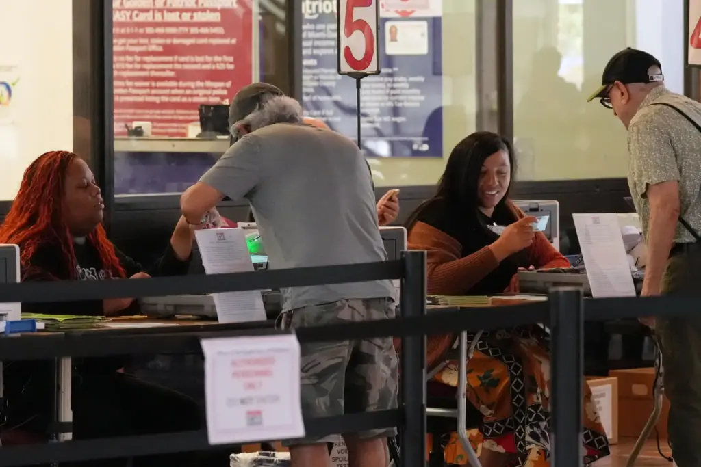 Miami-Dade Supervisors of Elections employees check identification documents of voters.