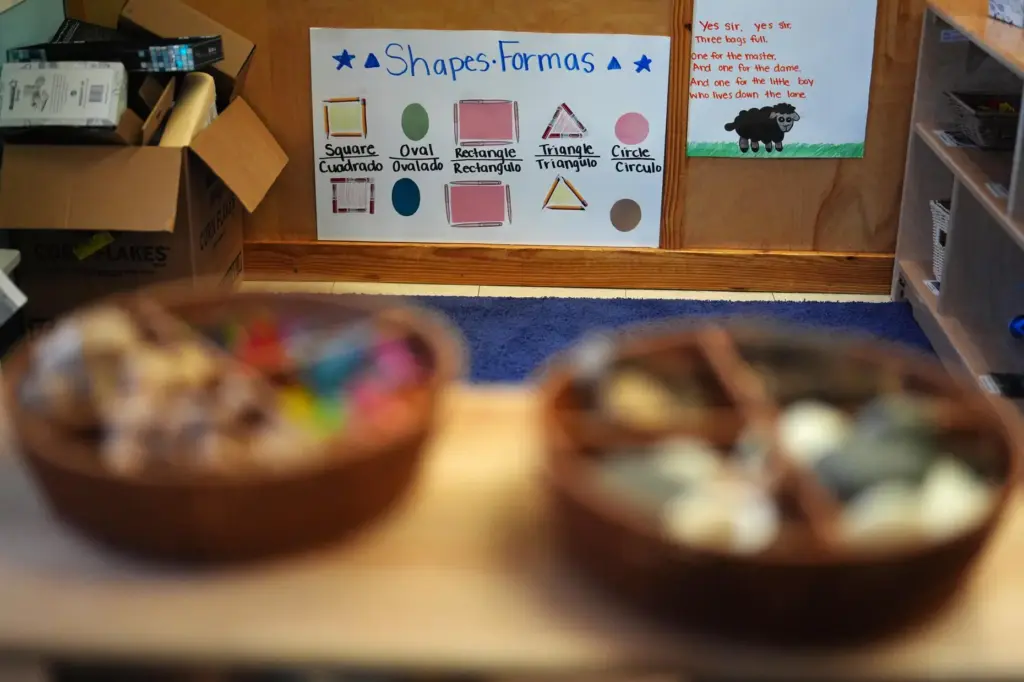 A poster shows common shapes labeled in both English and Spanish inside a classroom.