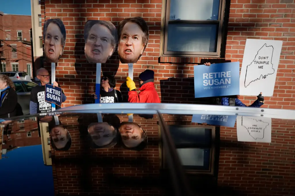 Protesters hold photos of U.S. Supreme Court Justice Brett Kavanaugh...