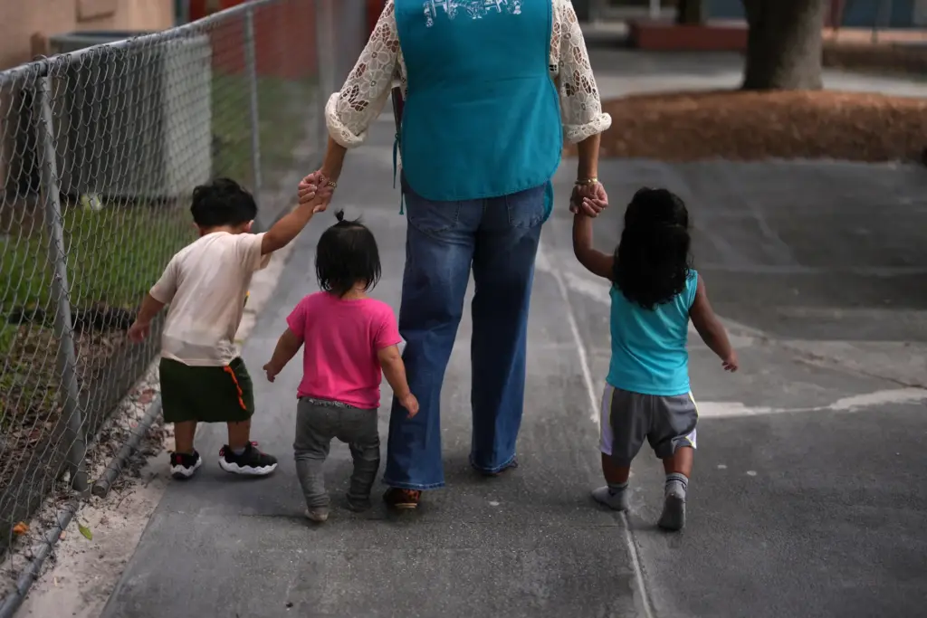 A teacher escorts young children back to their classroom at a Head Start preschool.