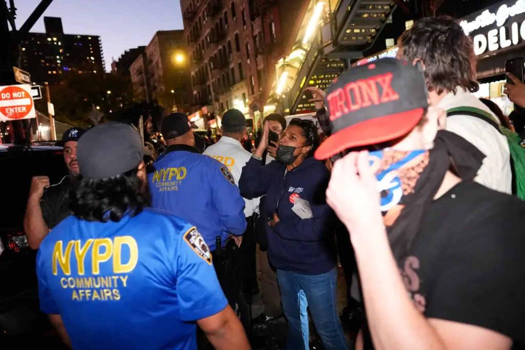 People confront law enforcement near the scene of a shooting...