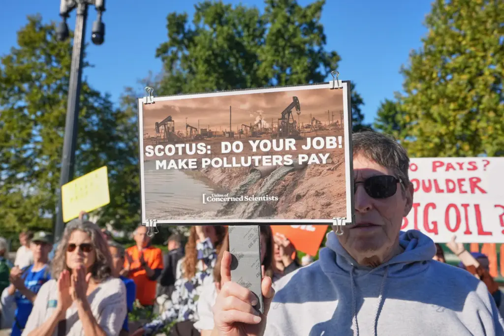 An activist carries a sign at the Supreme Court as...