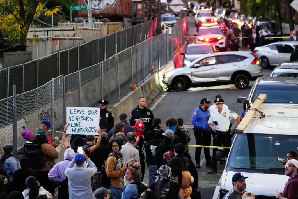 People gather at the scene of a shooting as law...
